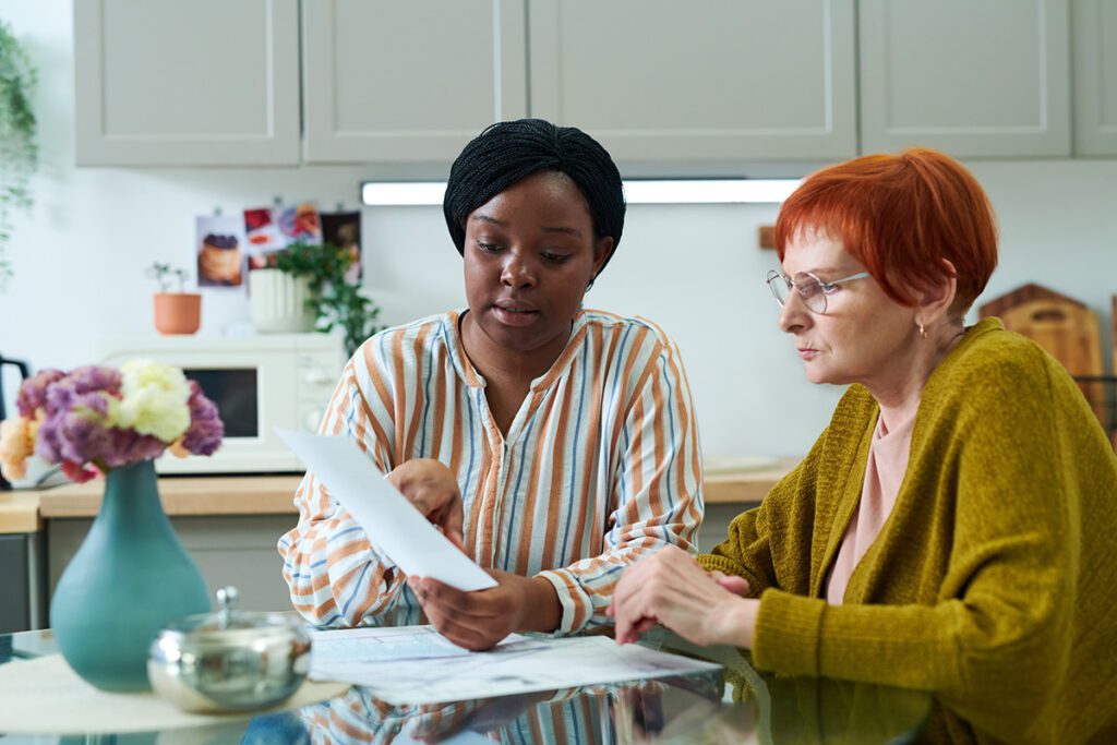 SIl Services Brisbane NDIS support coordinator reading a participant progress report with a Horizon Community Services support worker